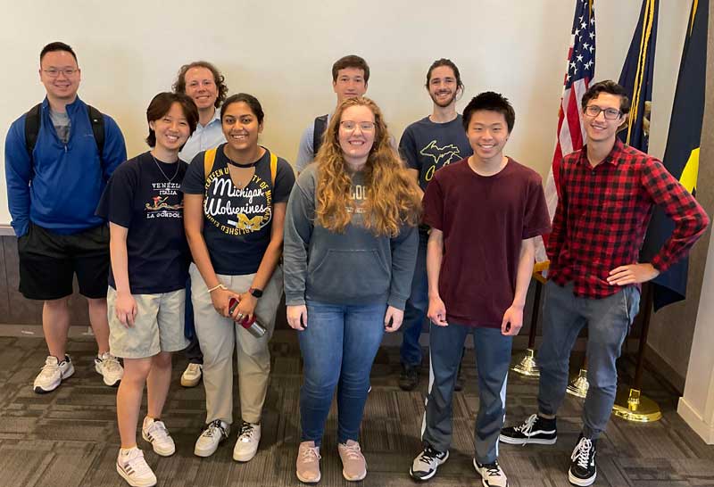 2023 ITS IA interns group photo with American, Michigan, and U-M flags.