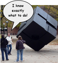 People standing around the U-M Cube sculpture. Onesays, "I know exactly what to do!"