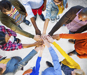 Arial view of people of different colors laying hands on top of each other