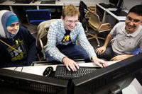 Three UM-Dearborn students sitting around a computer screen