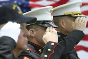 Member of the armed forces saluting with a U.S. flag
